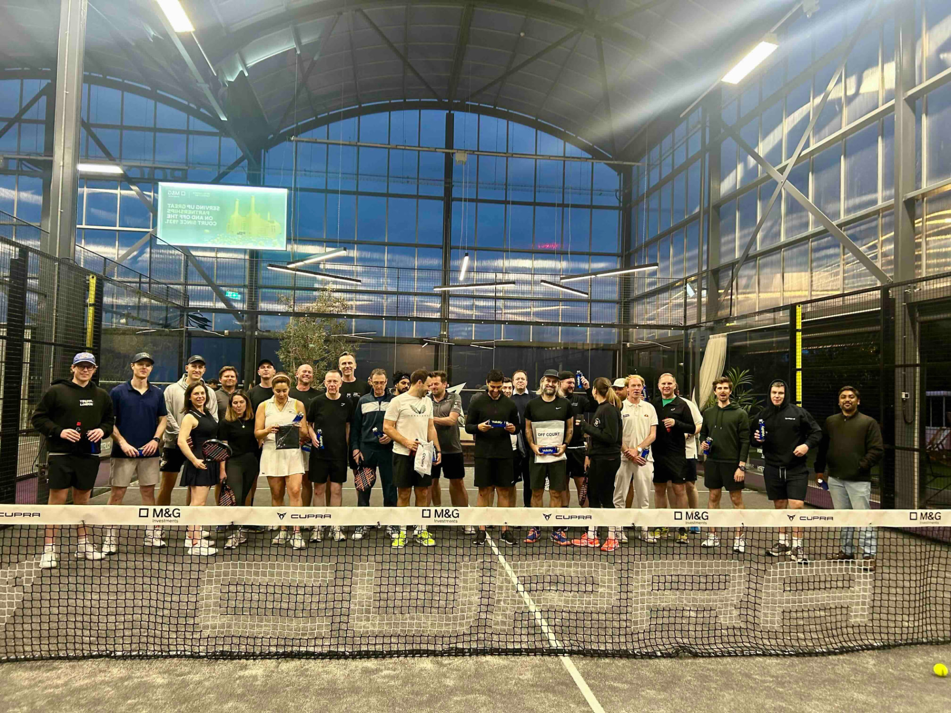 Club members gathered on court at an indoor padel venue in London