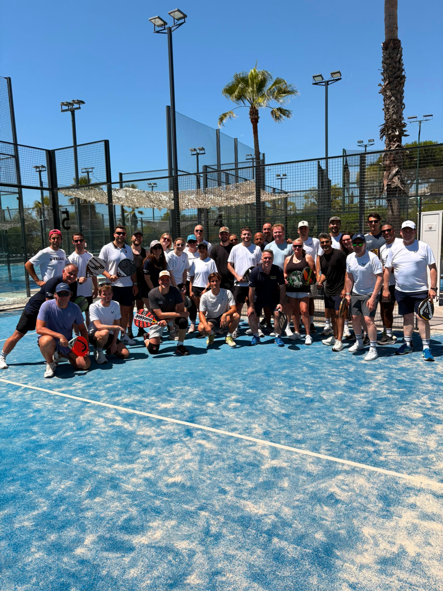 Club members on an outdoor padel court at a club event